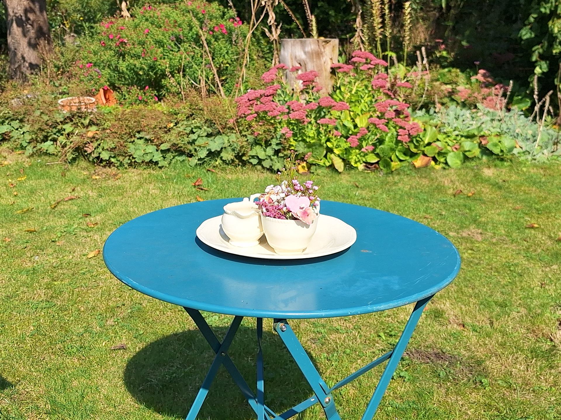 Theetuin van Rustpunt Lindtorphe met gedekt tafeltje en bloemen